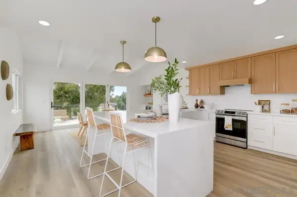 Kitchen with waterfall island and oak upper cabinets