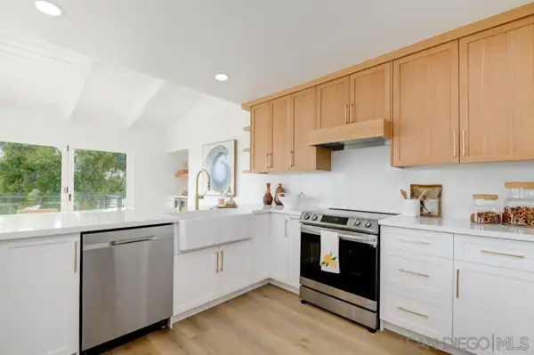Kitchen with white and oak cabinets and farmhouse sink