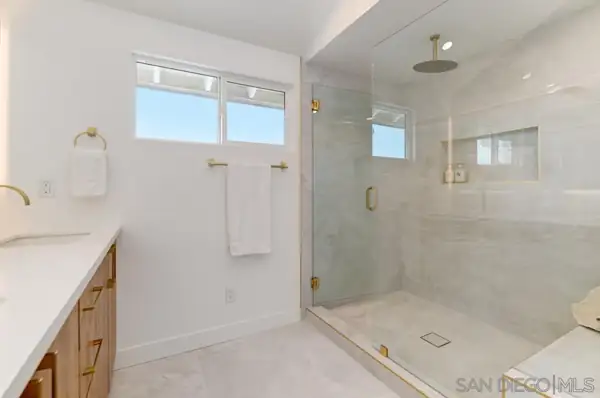 Bathroom with glass walk-in shower and brass fixtures