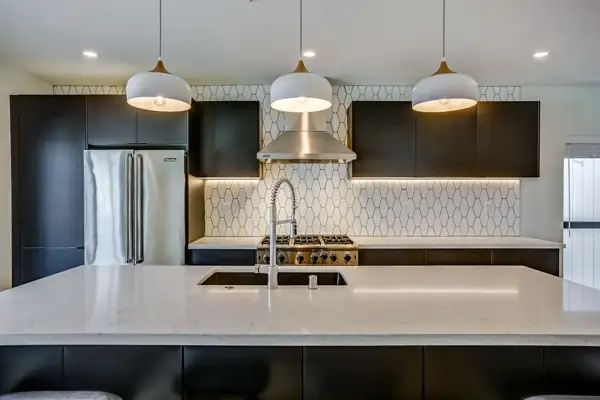 Crown Point Apartments: Kitchen with dark cabinets, white pendants and geometric tile backsplash