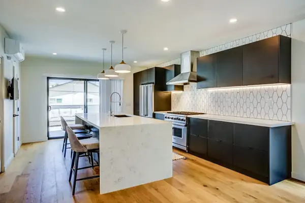 Kitchen with dark cabinets and waterfall quartz island