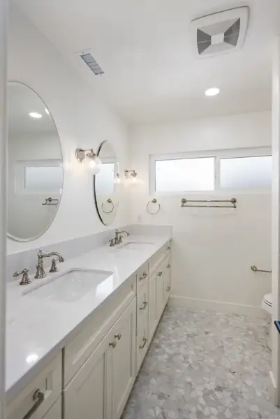 Bathroom with double vanity and oval mirrors
