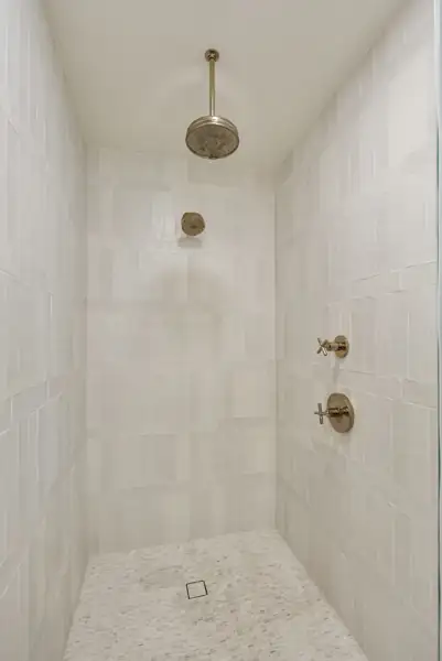 Tiled walk-in shower with brass rain head
