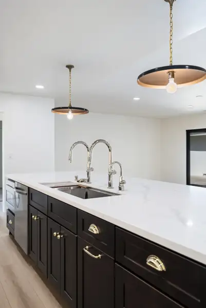 Kitchen island sink with polished faucets and brass hardware