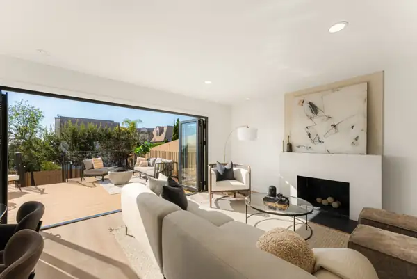 Living room with plaster fireplace and folding doors to the deck