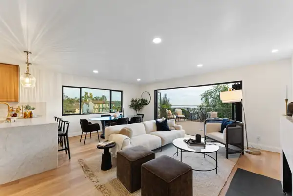 Living and dining room open to the deck with bay view