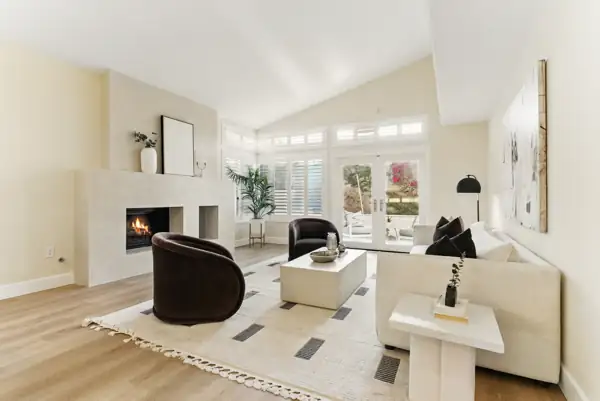 Living room with plaster fireplace and French doors to the patio