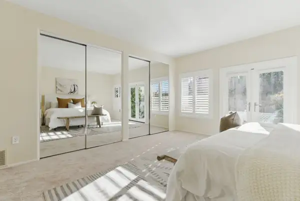 Bedroom with mirrored closet doors and French doors