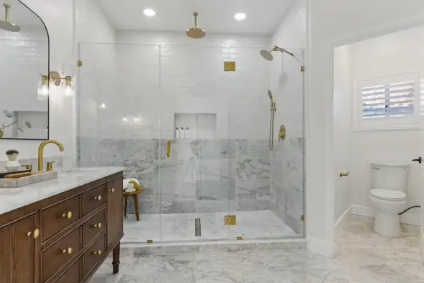 Primary bathroom with glass walk-in shower and marble tile