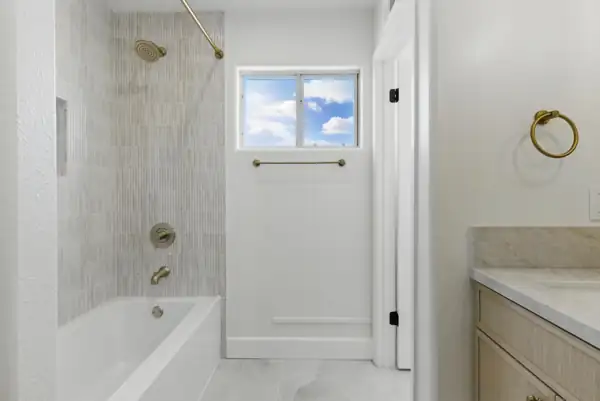 Bathroom with tiled tub surround and brass fixtures