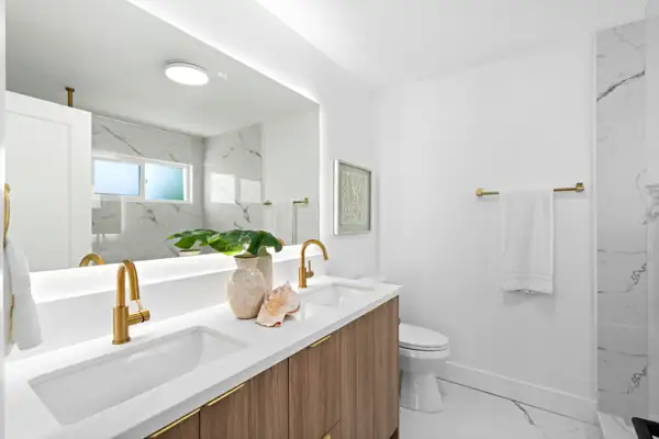 Bathroom with walnut double vanity and backlit mirror