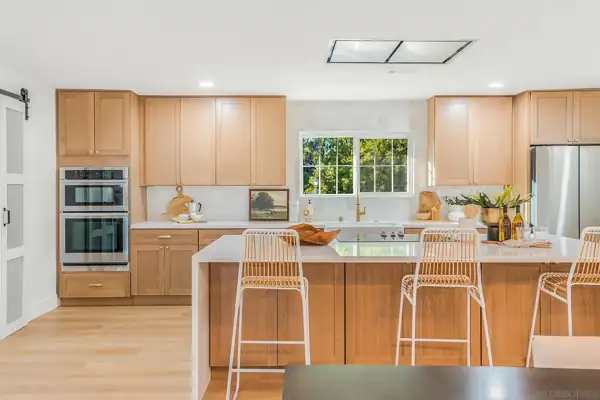 Poway: Kitchen with oak cabinets, waterfall island and rattan barstools