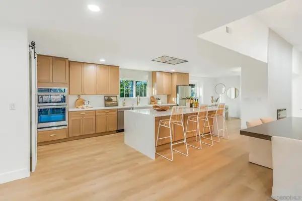 Kitchen with oak cabinets, double ovens and island seating