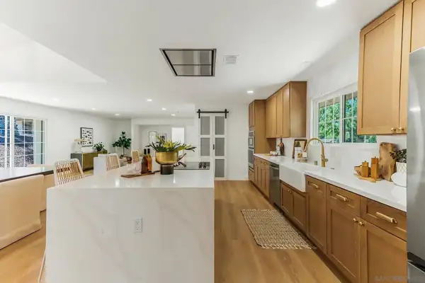 Kitchen island and oak cabinet wall with barn door beyond