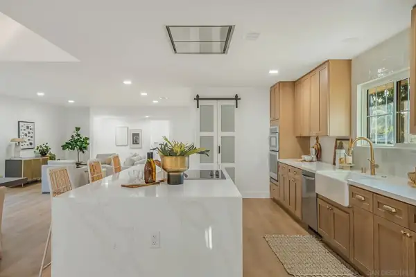Waterfall island with cooktop and family room beyond