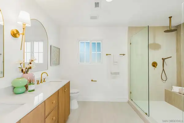 Primary bathroom with oak double vanity and walk-in shower
