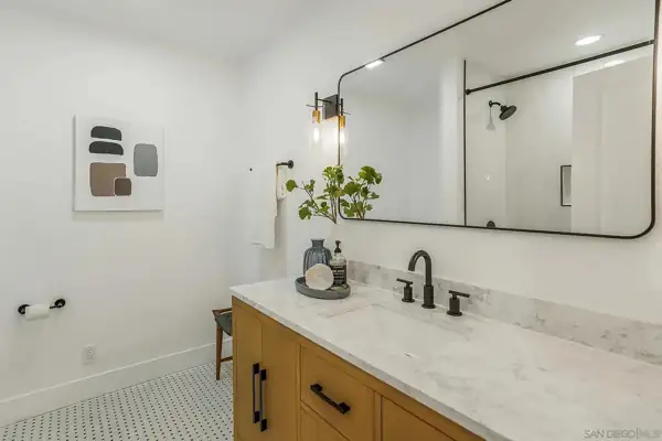Bathroom with oak vanity, marble top and black fixtures