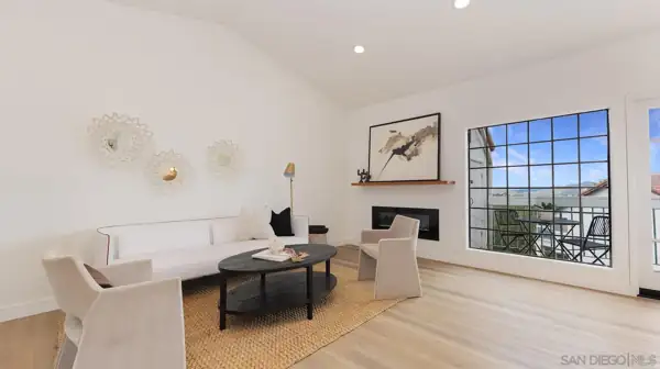 Living room with linear fireplace and balcony window