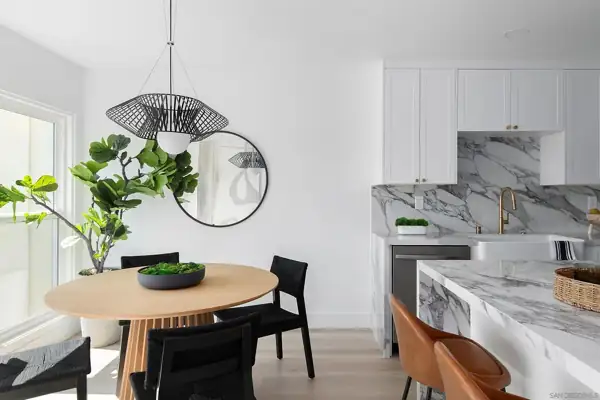Solana Beach Condo: Dining nook with wire pendant beside the marble kitchen
