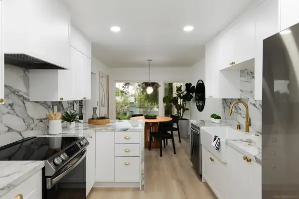 Galley kitchen with white cabinets and brass hardware