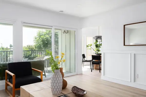 Living room with wainscoting and sliding doors to the balcony